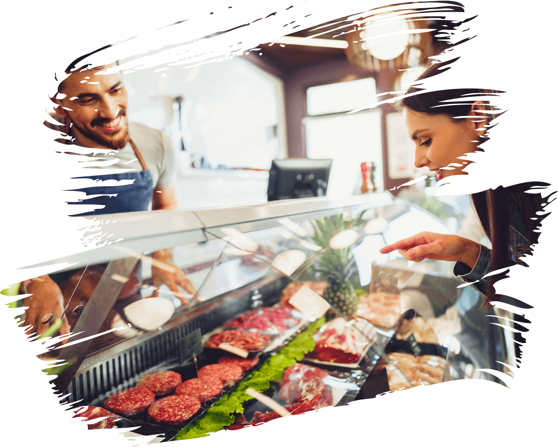 Customer selecting meat at a butcher's counter with staff assistance.